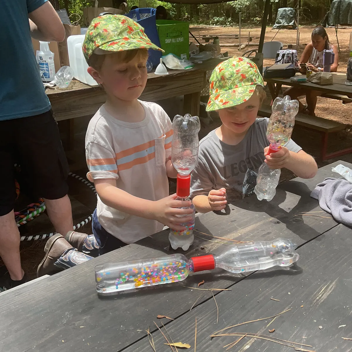 Students making sensory discovery bottles at a picnic table